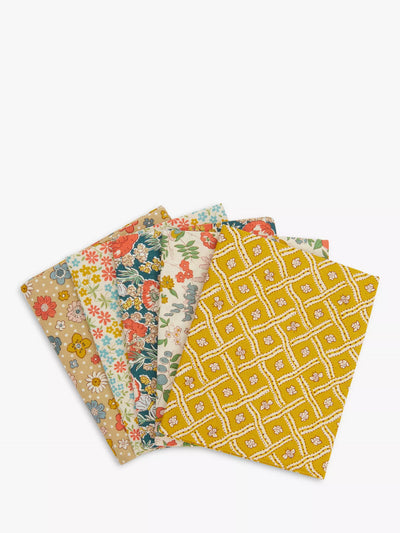 A set of five folded patternedLiberty  fabrics fanned out on a light gray background. The Liberty fabrics feature various vintage floral and geometric prints in yellow, beige, red, green, and blue.