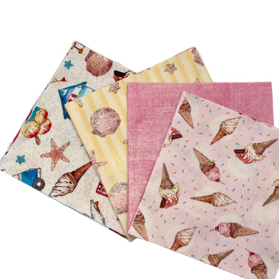 Four square fabric napkins or small paper napkins with different printed patterns are arranged in an overlapping fan shape on a light wood surface. The patterns include seashells and starfish on an off-white background, yellow stripes with seashells and stars, a solid pink fabric, and pink with ice cream cone prints on a light pink background.