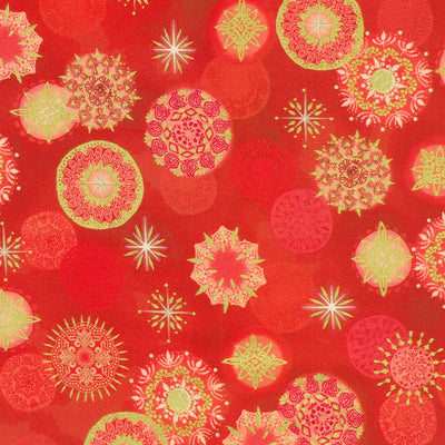 A close-up of a red patterned fabric or wallpaper featuring repeating mandala and starburst motifs in pale yellow-green and pink.