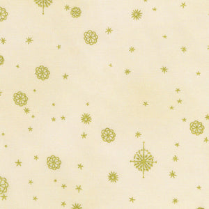 A close-up of a cream-colored fabric with a repeating pattern of small gold stars and floral snowflake motifs.
